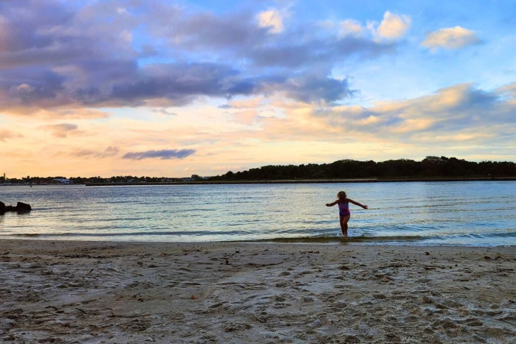 A child in the water at the Intracoastal beach at the Boynton Inlet Park.