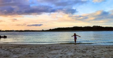 A child in the water at the Intracoastal beach at the Boynton Inlet Park.